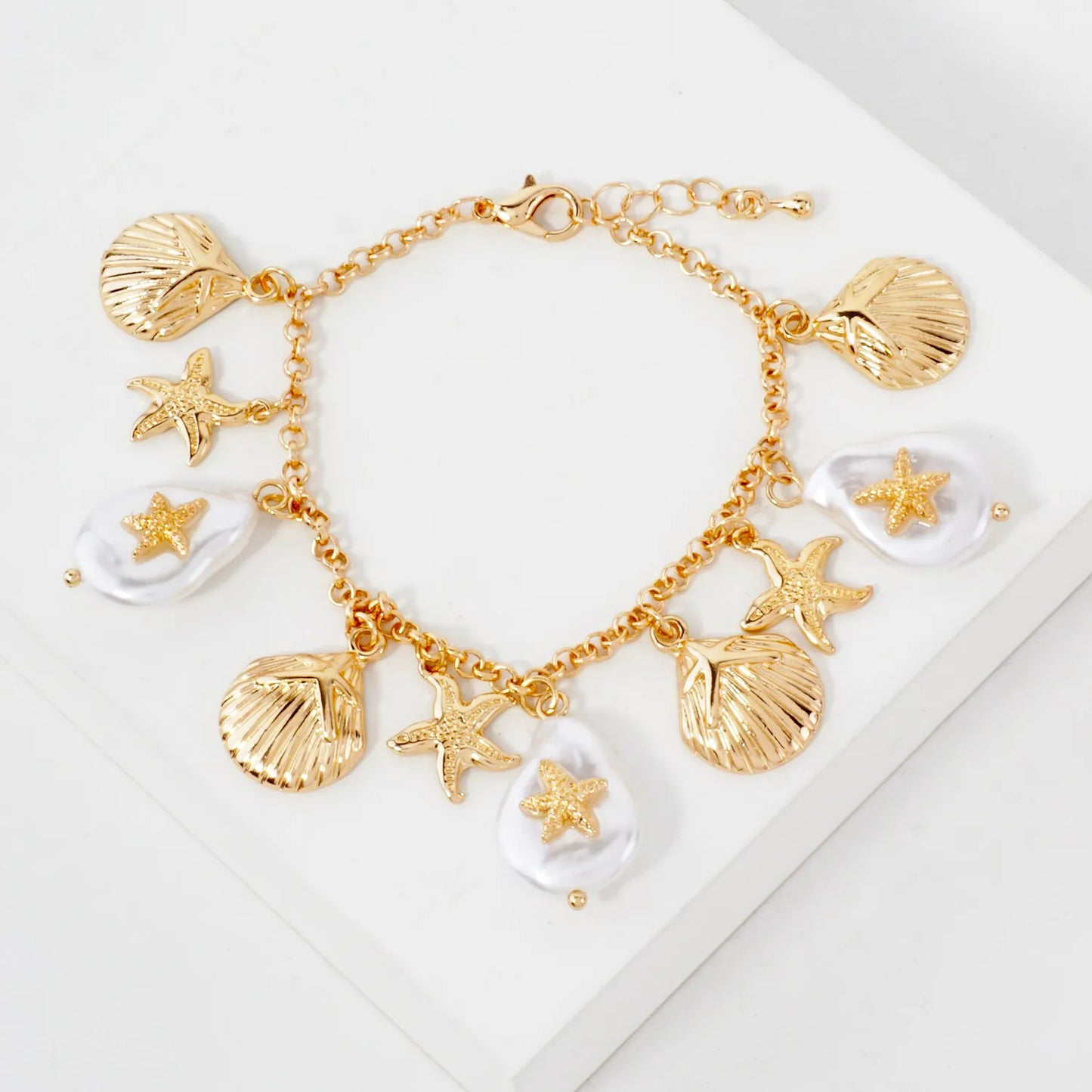 Gold bracelet with shell and starfish charms on a white background -Gaonnori korean cool jewelry